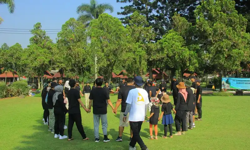 Kegiatan ice-breaking peserta corporate outing dan family gathering di Bogor, menampilkan kolaborasi tim di area outdoor. Di kejauhan tampak spanduk acara BoundEx.