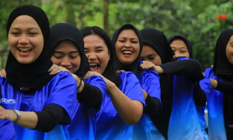 Peserta wanita dalam kegiatan gathering di Bogor tertawa lepas saat mengikuti sesi ice breaking "pijat ceria" yang dipandu oleh instruktur BoundEx Indonesia.