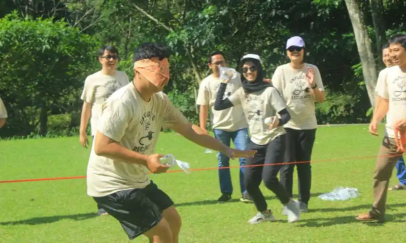Peserta fun outbound di Pancawati sedang mengikuti permainan gladiator dengan mata tertutup untuk melatih komunikasi dan kepercayaan antar anggota tim.