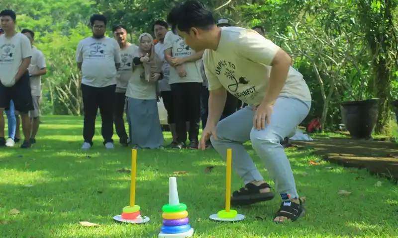 Peserta team building di Pancawati sedang mengikuti simulasi ketangkasan memasukkan ring ke dalam tiang untuk melatih koordinasi dan strategi pencapaian target dalam tim.