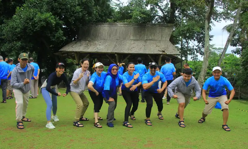 Peserta outbound karyawan berpose bersama setelah aktivitas energizer di area outdoor