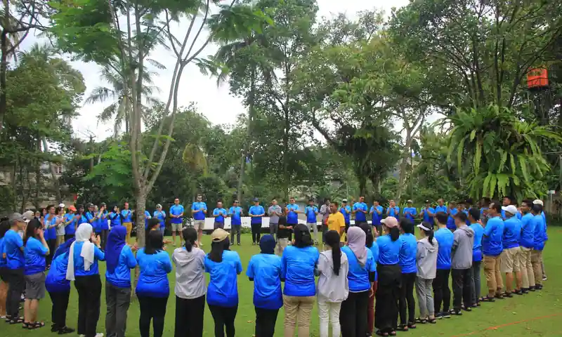 Peserta corporate outbound membentuk lingkaran briefing di area outdoor Puncak Bogor dengan fasilitator BoundEx.