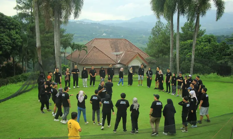 Tim perusahaan mengikuti sesi outbound di lapangan hijau Puncak Bogor sebelum paintball, memperlihatkan suasana team building yang terarah, alami, dan cocok untuk kegiatan corporate.