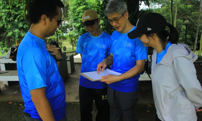 Peserta team building berdiskusi menggunakan lembar tugas dalam aktivitas problem solving games.