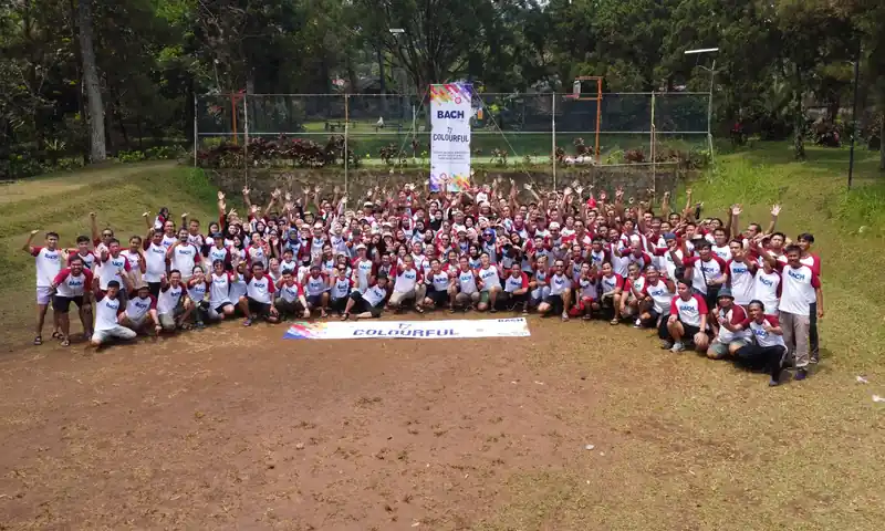 Kelompok peserta kegiatan outbound dan gathering berfoto bersama di area terbuka.