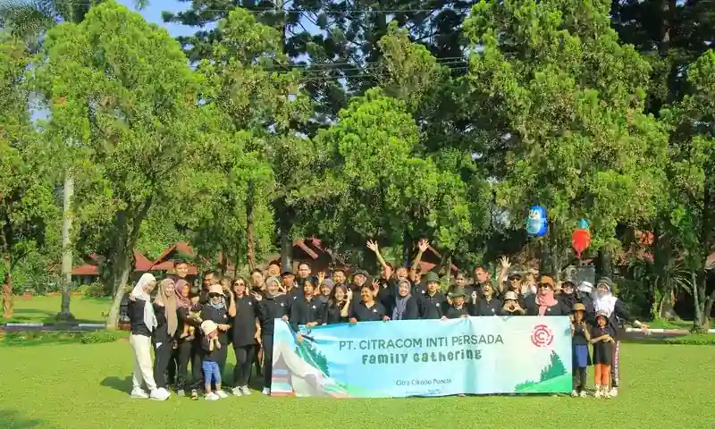 Peserta family gathering perusahaan di Bogor berfoto bersama di area resort outdoor dengan banner acara