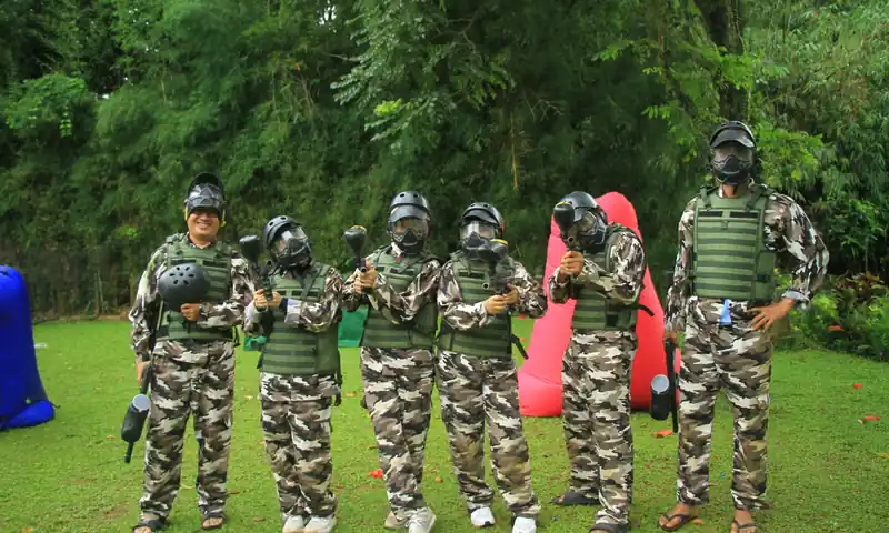 Peserta perusahaan memakai perlengkapan paintball dalam kegiatan gathering outdoor di Bogor