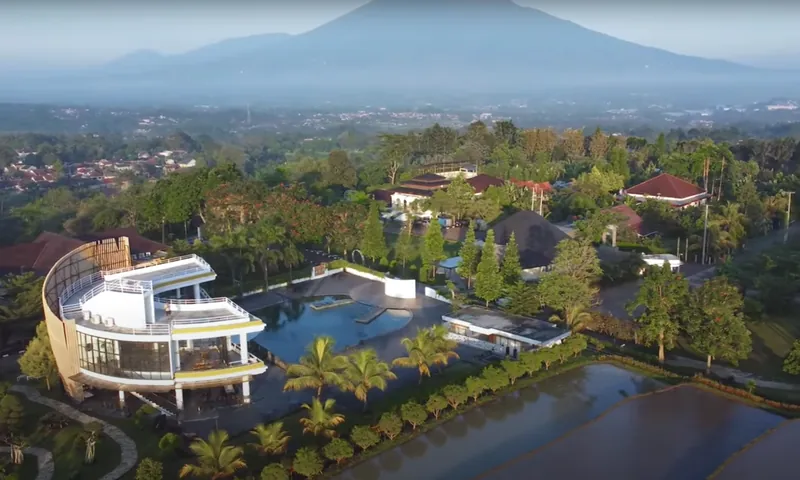 Tampilan udara area Padi resort hijau di Pancawati dengan latar pegunungan untuk konteks gathering perusahaan