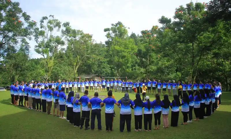 Peserta team building membentuk lingkaran di area outdoor Bogor
