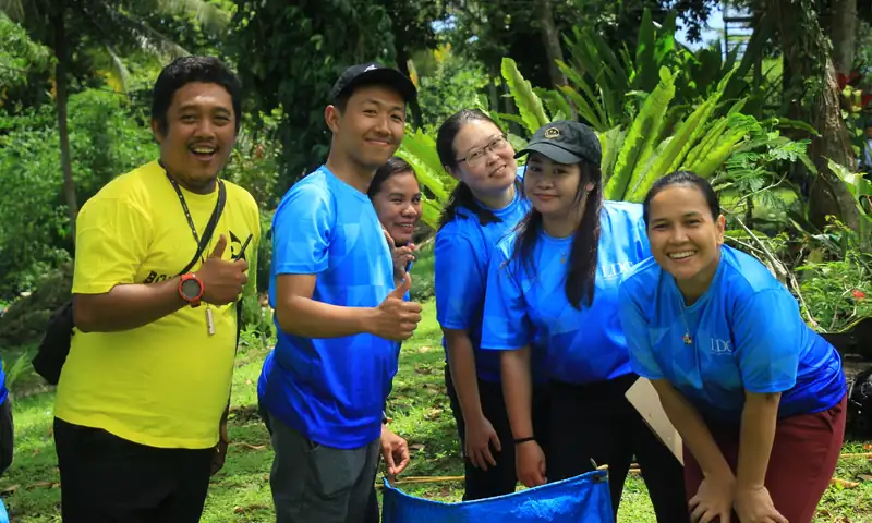 Peserta team building berpose bersama fasilitator setelah aktivitas kelompok outdoor