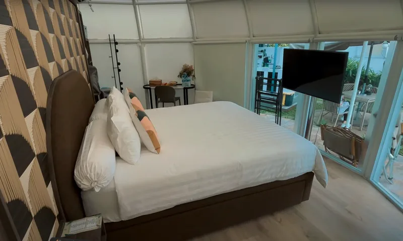 Interior kamar glamping Teras Bhumi Puncak dengan tempat tidur dan akses kaca ke area luar